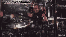 a video of a man playing a guitar with the name bon jovi behind him