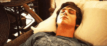 a young man is laying in a chair with his eyes closed and the word sky is visible in the corner