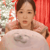 a woman in a pink dress looks at a stuffed animal