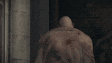 a statue of a man with a very long neck is standing in a dark room .