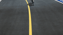 a person riding a bike on a road with a yellow line on it