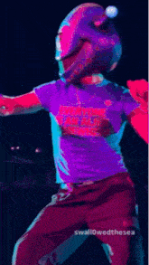 a person wearing a blue shirt and a blue helmet is dancing on stage .