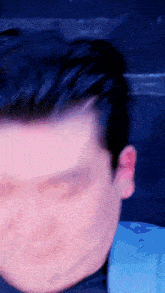 a blurry photo of a man 's face with a blue background