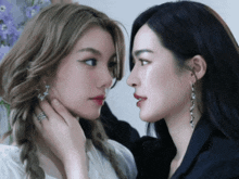 two women looking at each other with one wearing a ring on her finger