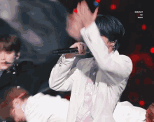 a man in a white jacket is holding a microphone and the words kickstart my heart are visible