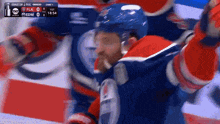 a hockey player celebrates a goal during a game against the flames