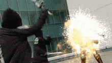 a person in a black jacket with a skull on it is holding a sword in front of a building