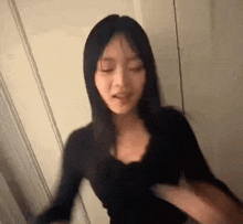 a woman is standing in a room with her eyes closed and a blurry picture of her face .