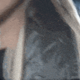 a close up of a woman 's face with a feathered jacket on