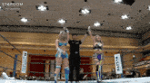two women wrestling in a ring with a sign that says stardom on it