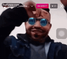 a man wearing sunglasses is making a funny face in a live stream