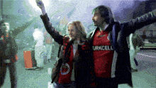 a man and a woman wearing turkcell shirts are dancing