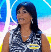 a woman wearing a name tag that says gretchen is smiling and looking at the camera .