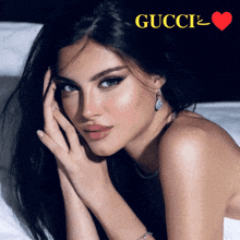 a woman is laying on a bed with a gucci logo above her head