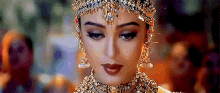 a close up of a woman 's face wearing a crown and jewelry .