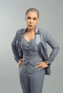 a woman with a shaved head wearing a grey suit