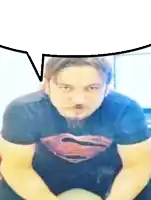 a man with a beard wearing a superman shirt is sitting on a chair .