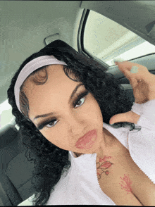 a woman in a car with a tattoo on her chest