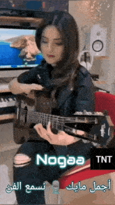 a woman is playing a guitar with the name nogaa on the bottom right