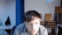 a blurry picture of a man in a room with stacks of chairs
