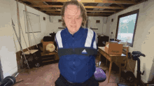 a man in a blue adidas jacket is in a room