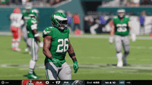 a football player wearing a green jersey with the number 26 on it