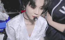 a close up of a person wearing a white shirt and a microphone