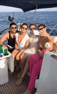 a group of people taking a selfie on a boat in the ocean