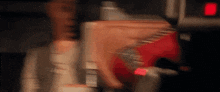 a blurry picture of a person holding a red object in a dark room .