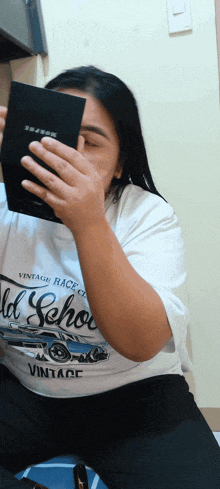 a woman wearing a vintage race club shirt looks at herself in the mirror