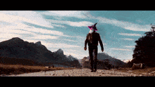a man wearing a witch hat walking down a dirt road