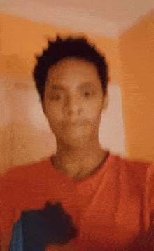 a blurry picture of a man wearing an orange shirt