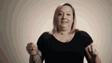 a woman with pink hair and a tattoo on her chest is pointing