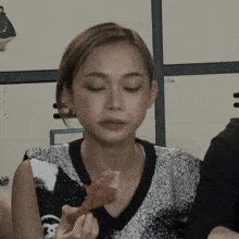 a woman with her eyes closed holds a piece of meat in her hand