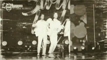 two women are dancing in front of a sign that says " rainbow factory "