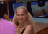 a woman with blonde hair and pigtails is smiling and looking at the camera .