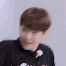a blurry picture of a young man wearing a black shirt with a flower in his hair .