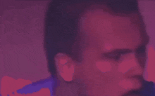 a blurry picture of a man 's face in a purple and red light .