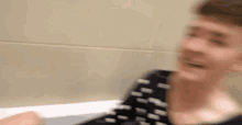 a young man is sitting in a bathtub and talking to someone .