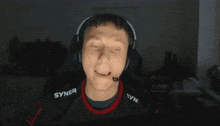a man wearing headphones and a shirt with syner on it