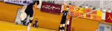 a volleyball game is being played in a stadium with a sign that says ' tokyo ' on it