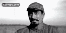 a black and white photo of a man wearing a hat and jacket .