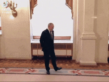 a man in a suit is walking down a hallway