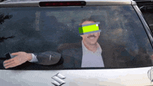 a man in a car with a suzuki logo on the back window
