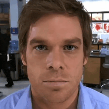 a close up of a man 's face in a blue shirt in a lab .