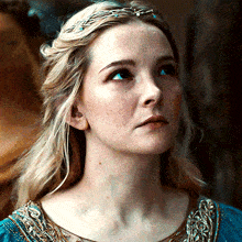 a close up of a woman 's face with a blue dress on