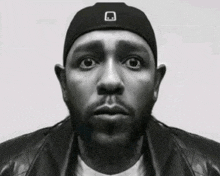 a black and white photo of a man wearing a hat and a jacket
