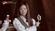 a woman wearing glasses is holding a magnifying glass in her hand