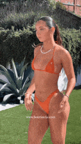 a woman in a bikini with the website www.boutinela.com written below her