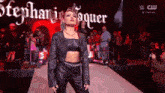 a woman in a leather jacket is walking down a ramp with the name stephanie vaquer written on the bottom